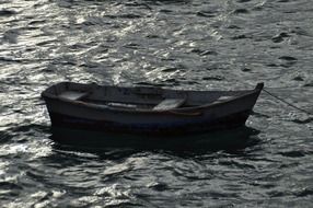 black and white photo of an old empty fishing boat at sea