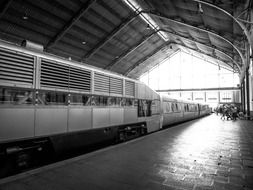 passenger train at railway station, black and white