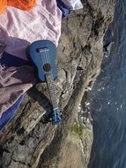 towel and guitar on the ocean coastline
