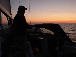 sail man in boat sunset scene