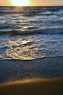 bright sun at dark water, view from beach