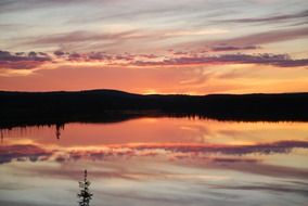 Beautiful and colorful twilight over the lake with silhouettes on the coast