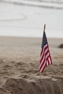 american flag on sand at the beach