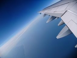 grey airplane wing in blue sky