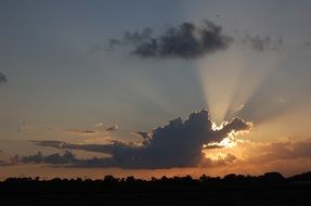 the sun behind the cloud at dusk