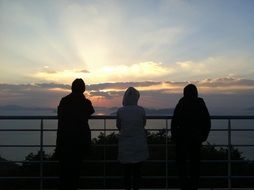 silhouettes of friends watching the sunset