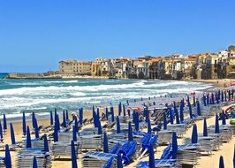 closed beach parasols and chairs on seaside, italy, sicily, cefalu