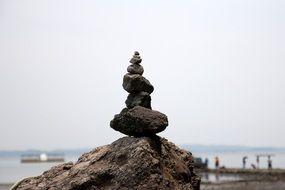 stone pyramid on a big stone on a beach