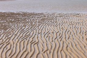 traces of sea waves on sand beach