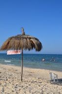 straw beach umbrella on a sunny beach