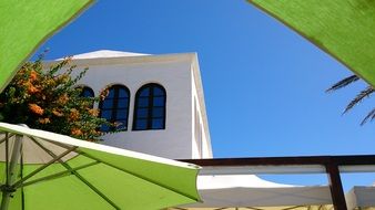 view from under the umbrella on a white villa in Spain