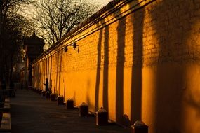 sunset light and shadow on aged stone wall, china, beijing