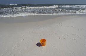 bucket on the sand near the sea on a sunny day