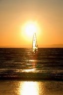 windsurfing in the rays of a bright sunset