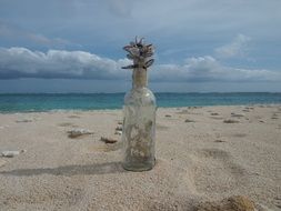 shells in a transparent bottle on the beach in Yoron