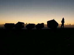 silhouettes of fishing boats at sunset
