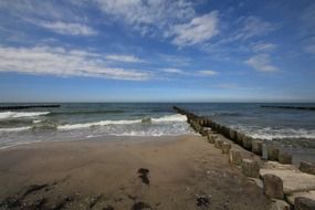 long breakwaters on beach at sea
