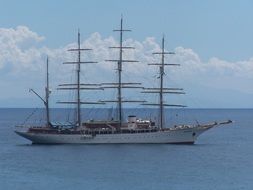 distant view of a four masted ship on the water