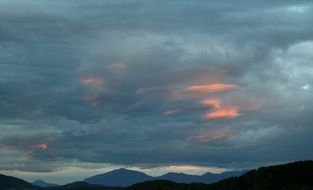 atmospheric thick clouds with flashes of red sun