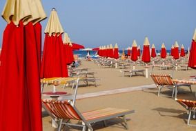 closed umbrellas near sun loungers on the beach