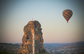 a balloon over the sea with a rock