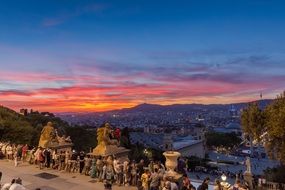 people looking at sunset city from montjuic hill, spain, barcelona