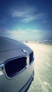 front of grey bmw car at ocean beach