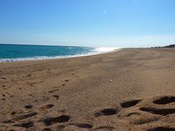 footprints on beach at sea