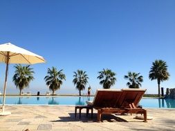 two sunbeds in front of swimming pool