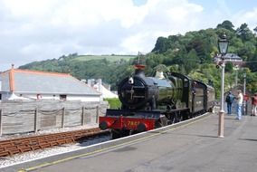 old steam locomotive with passenger cars at station