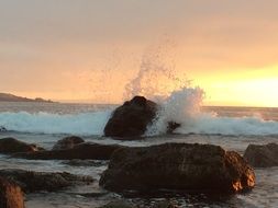 splashing water on stones at the beach