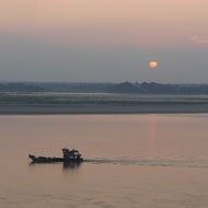 fishing boat at sea at sunset