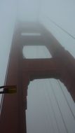 View from below on the bridge of the golden gate in the fog, america