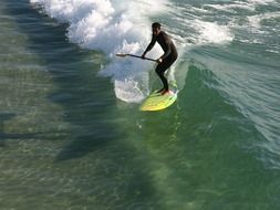 surfer with paddle in Huntington Beach