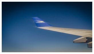 wing of plane in flight at sky