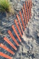 Top view of a fence on a sandy beach