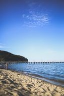 distant view of the pier on a sunny sandy beach
