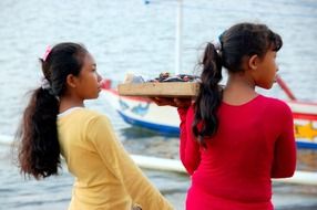 two child girls salling souvenirs at sea, bali