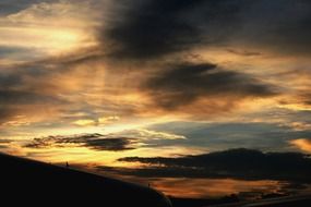 dark plane wing in colorful sunset sky