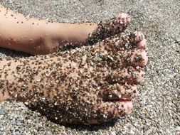 gray beach sand on feet