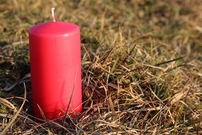 red candle on the grass