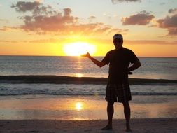 man holding the sun on the beach