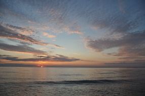 feather clouds over the sea at sunset