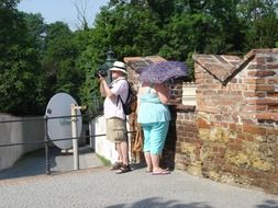 fat tourists on sun at aged wall, czech, prague