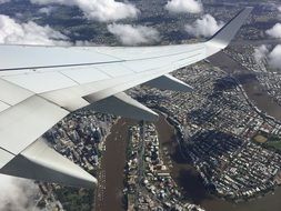 white wing of the plane over the city