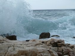 spray of ocean waves near the stone close-up