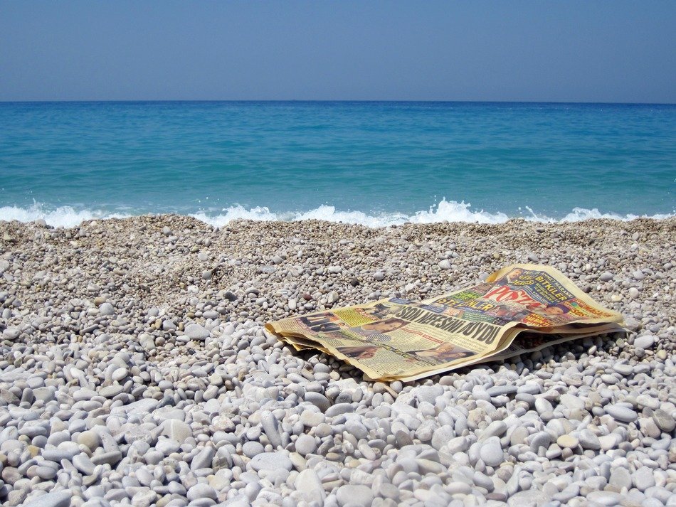 old newspaper on a pebble beach