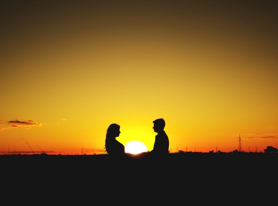 bright setting sun in the hands of a couple in love
