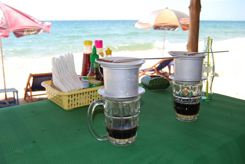 vietnamese coffee cups on table near ocean