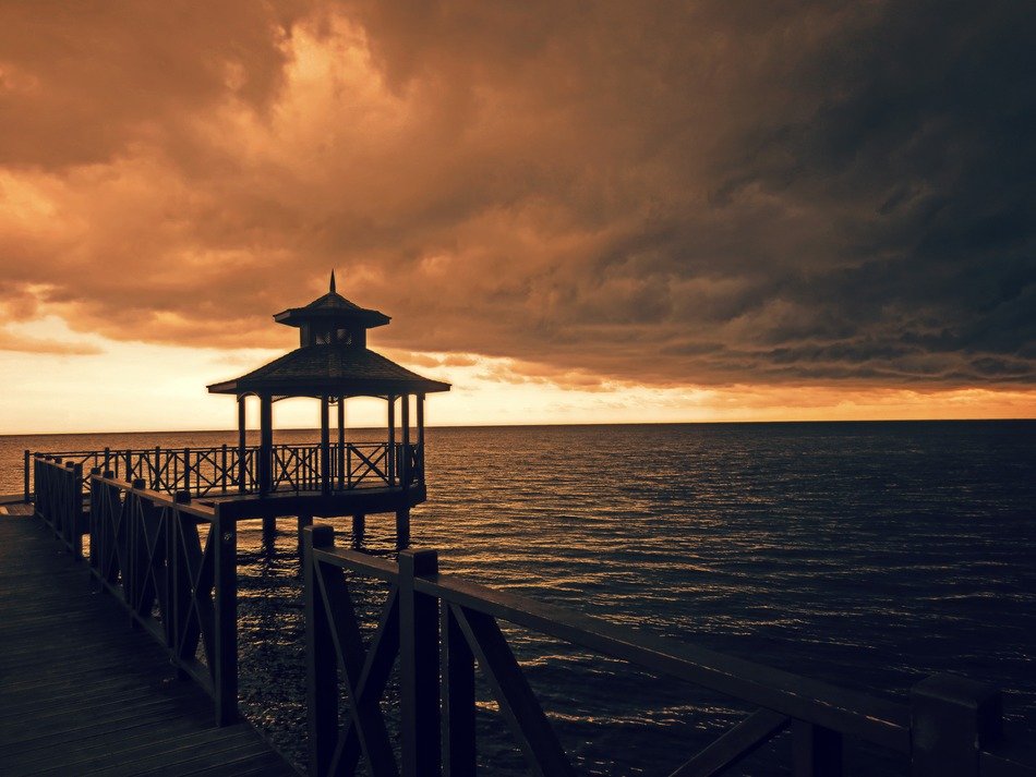 boardwalk above dark sea at sunset, jamaica
